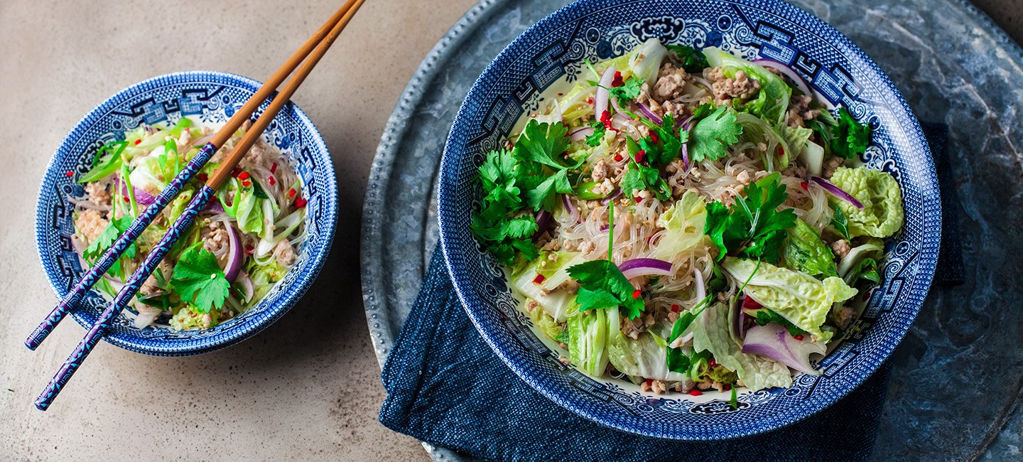 Салат со стеклянной лапшой и курицей на тарелке