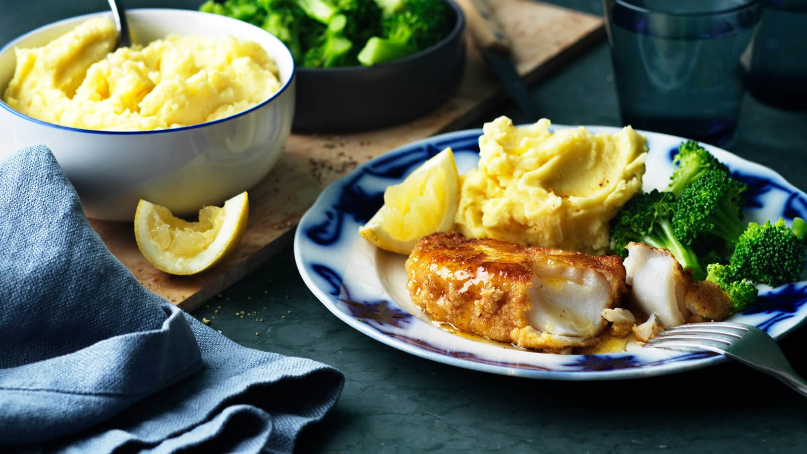 Fisk, potatismos och broccoli upplagt på en tallrik