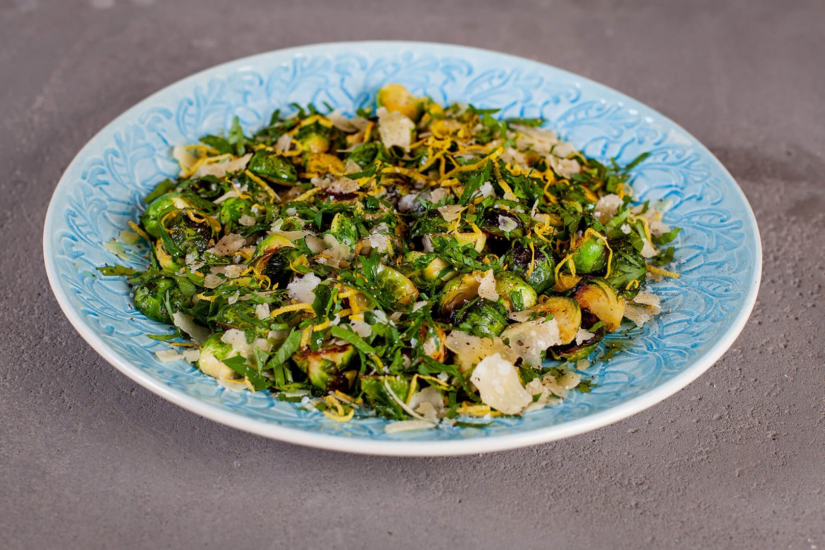 Stekt brysselkål med gremolata och parmesan på ett blått serveringsfat