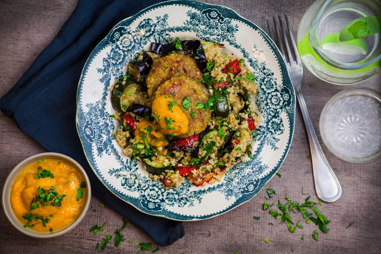 Kikärstbiffar med bulgur och rostade grönsaker på en tallrik