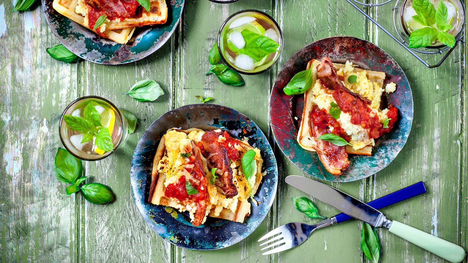 Waffle with scrambled eggs, bacon and salsa on a plate