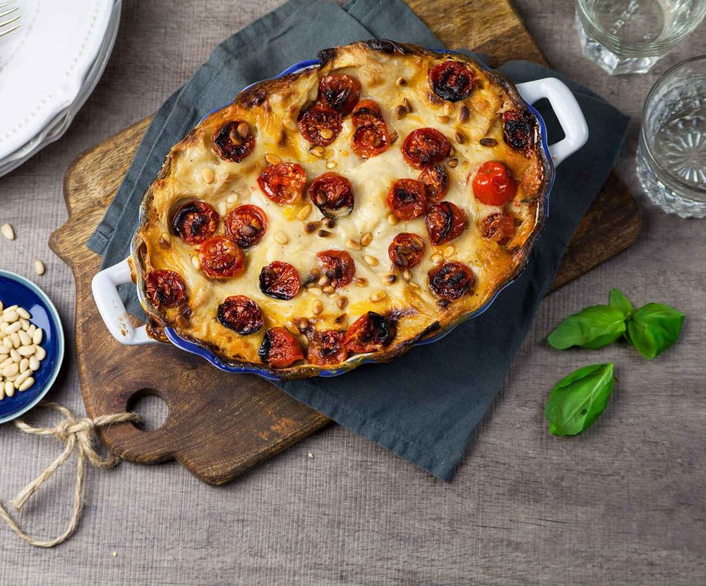 Vegan lasagne with cherry tomatoes in an ovenproof dish